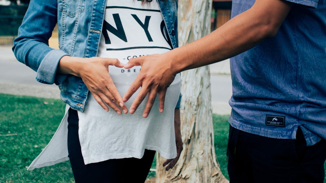 En esta fotografía, vemos a la pareja de una mujer apoyándola durante su embarazo