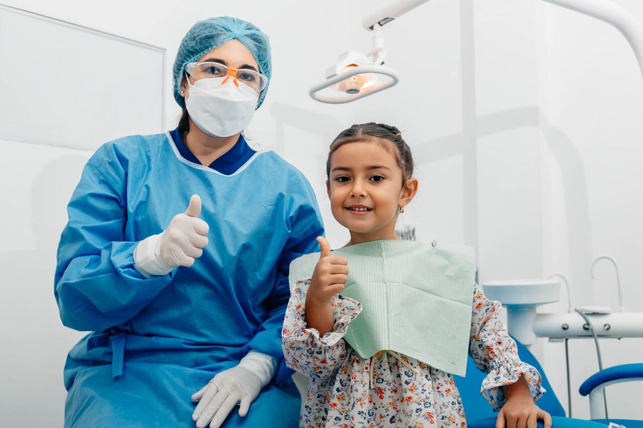 En esta imagen, vemos a una dentista tratando la caries de un paciente infantil