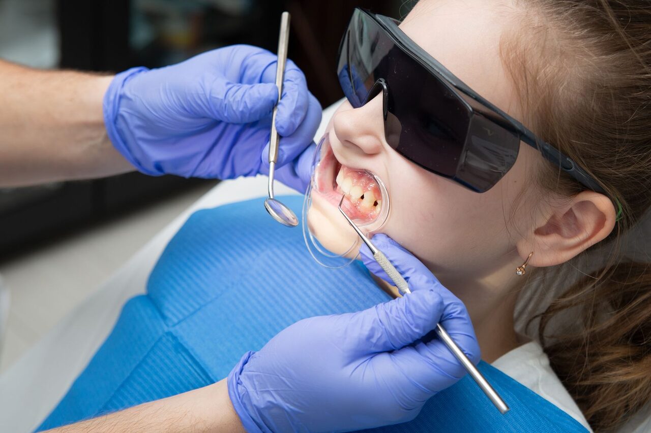 En esta imagen, podemos ver a una niña frente a una radiografía bucodental