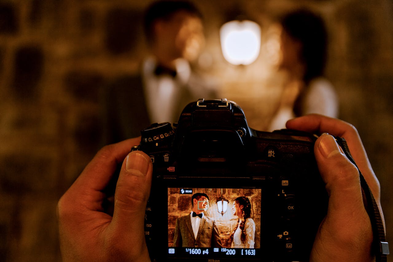 En esta imagen, vemos una cámara inmortalizando una escena matrimonial iluminada artificialmente