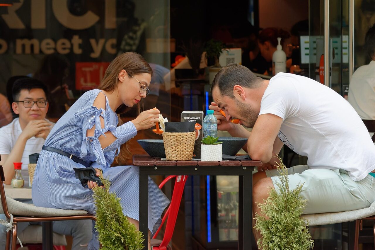 En esta fotografía, vemos a unas personas comiendo pastas y bebiendo café