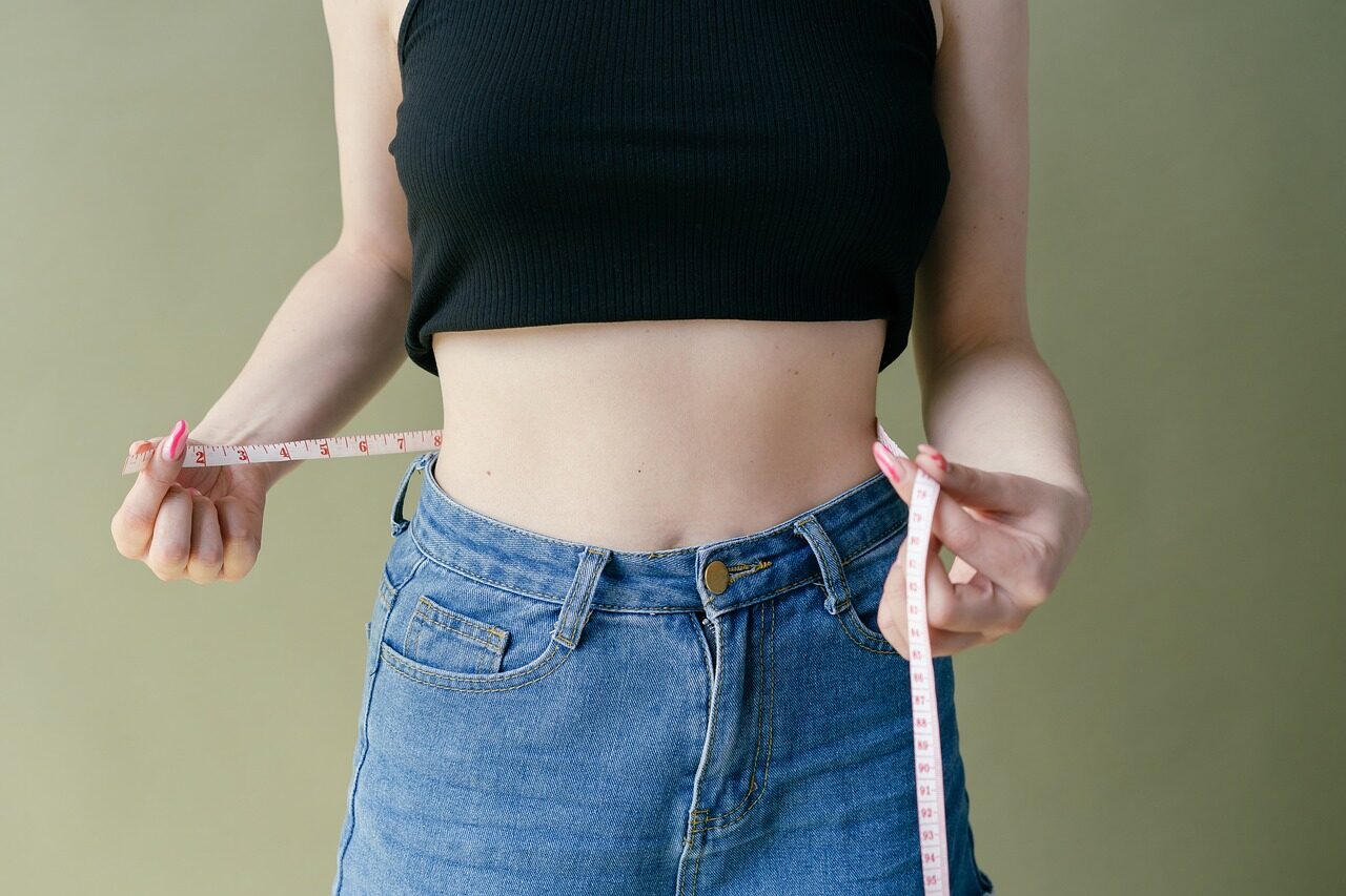En esta fotografía, vemos a una nutricionista profesional tomando las medidas de una paciente