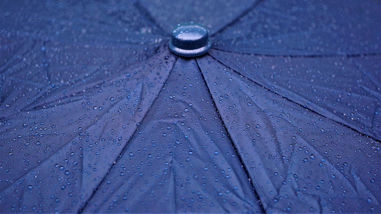 En esta imagen, vemos una lluvia intensa impactando en un paraguas