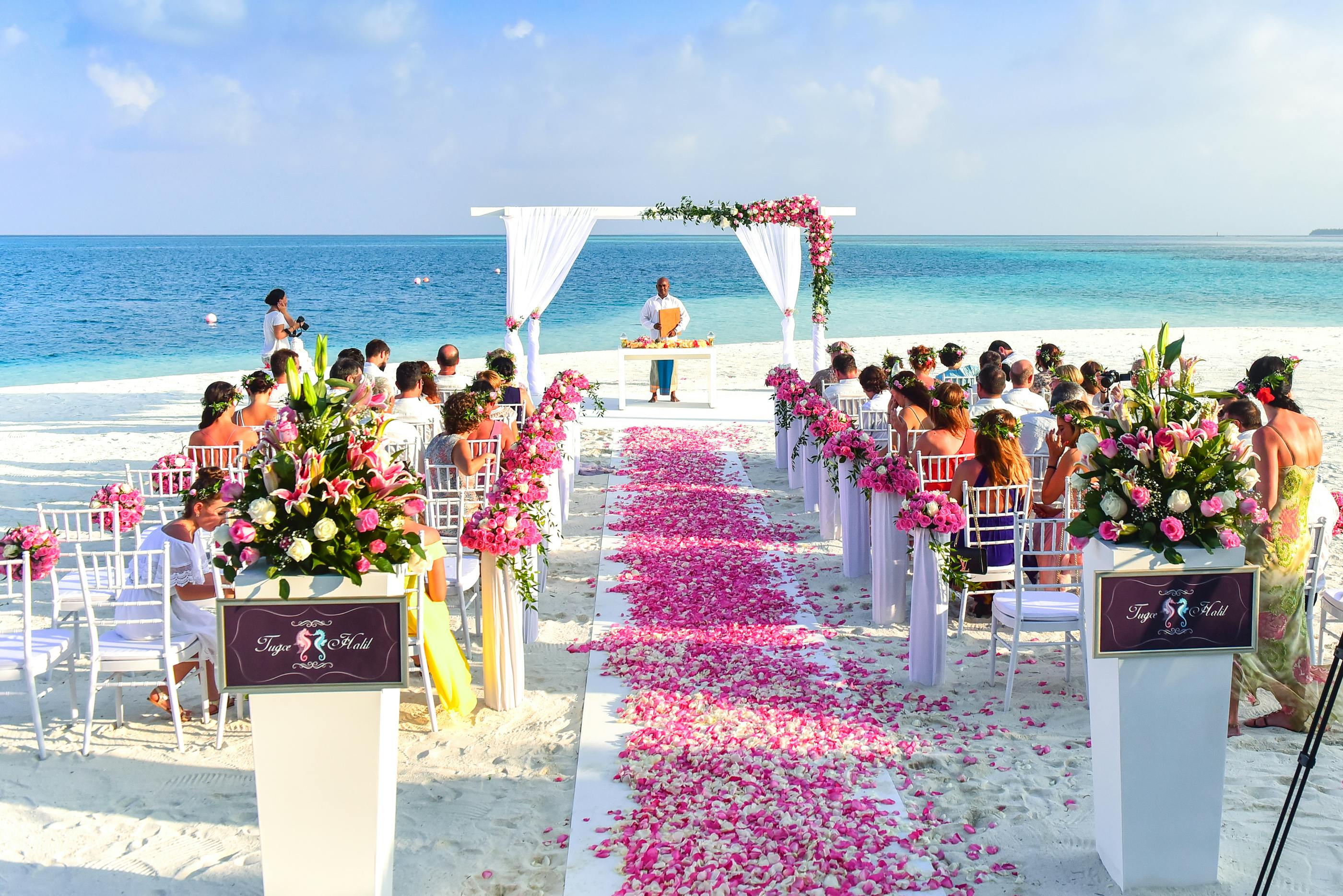 En esta imagen, vemos a varios invitados jóvenes y de mediana edad en una boda celebrándose en la playa